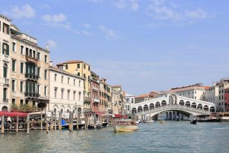 Which famous city is made up of 118 small islands in Italy and attracts millions of visitors each year